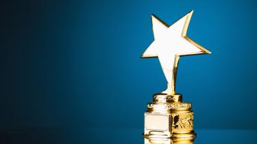 golden trophy with a star on top against a blue background