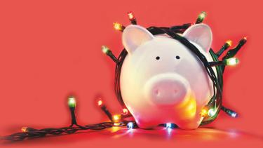 red background with a pig piggy bank wrapped in Christmas lights