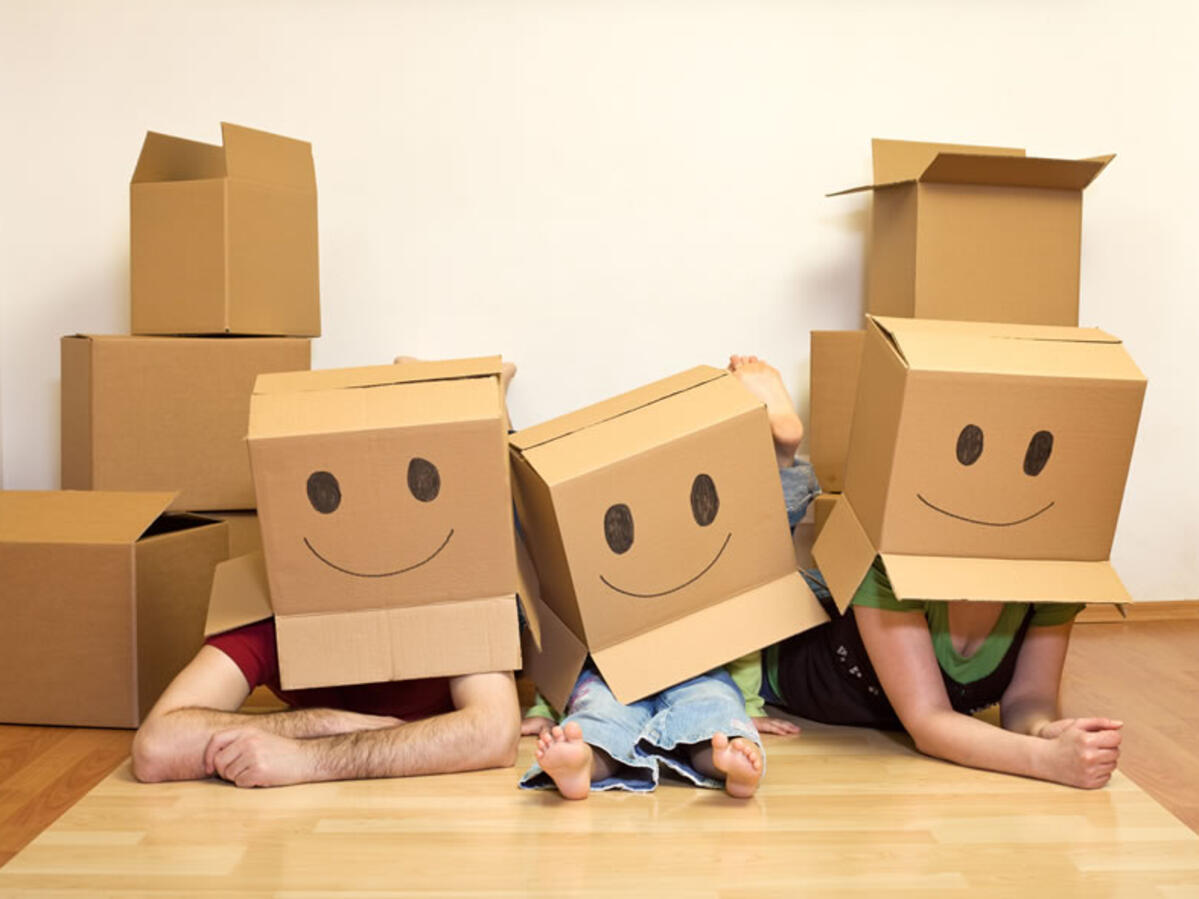 a family with moving boxes over their heads