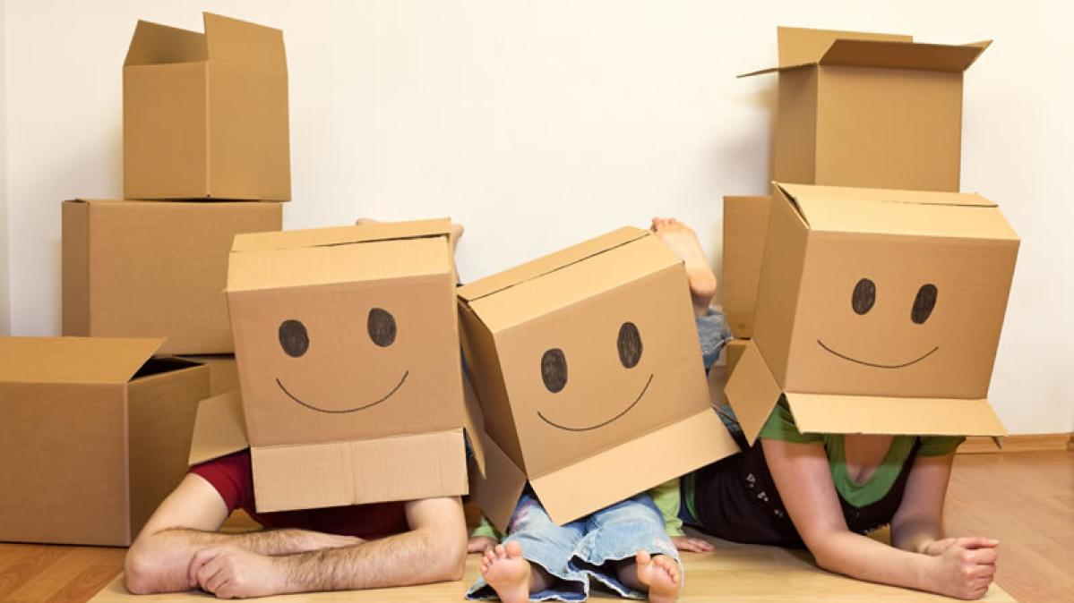 a family with moving boxes over their heads