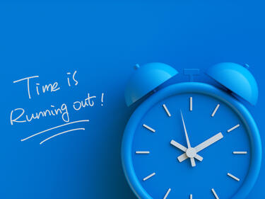 a blue clock with words written that time is running out. 
