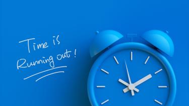 a blue clock with words written that time is running out. 