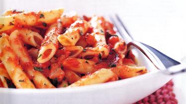 pasta with red sauce in a bowl with a fork on the side