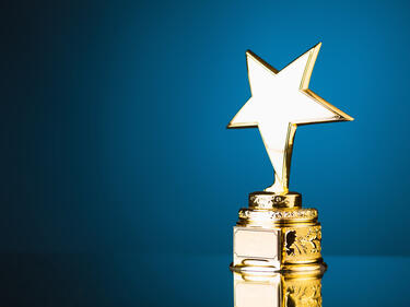 golden trophy with a star on top against a blue background