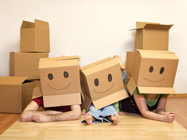 a family with moving boxes over their heads