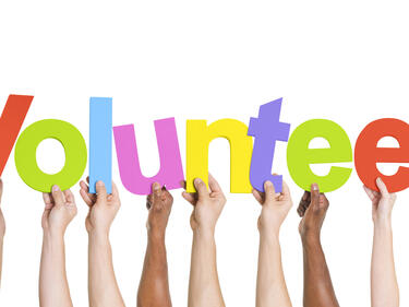 hands holding up the letters volunteer