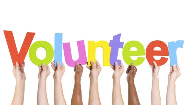 hands holding up the letters volunteer